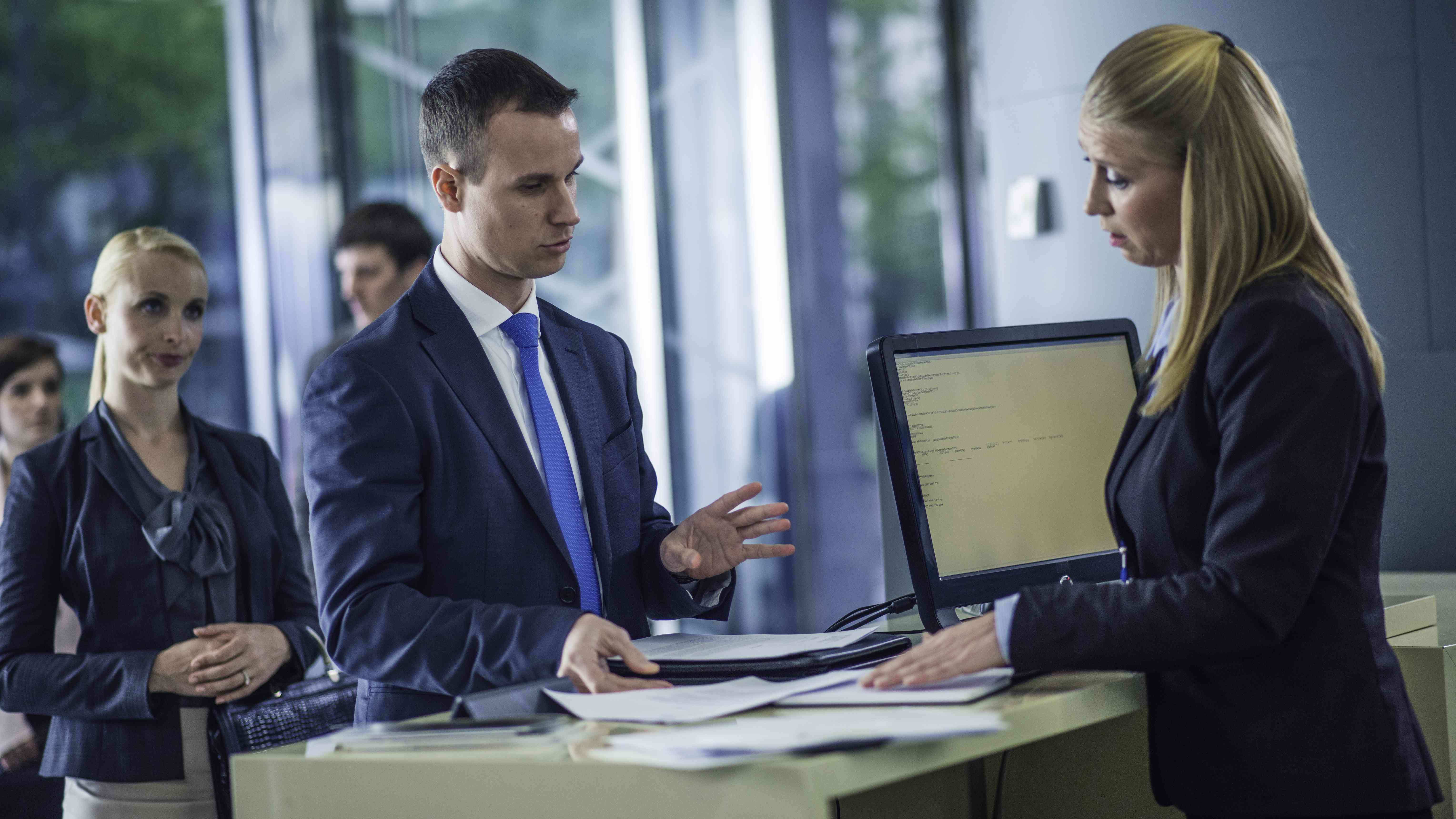 Customer asking questions of a bank teller at the counter