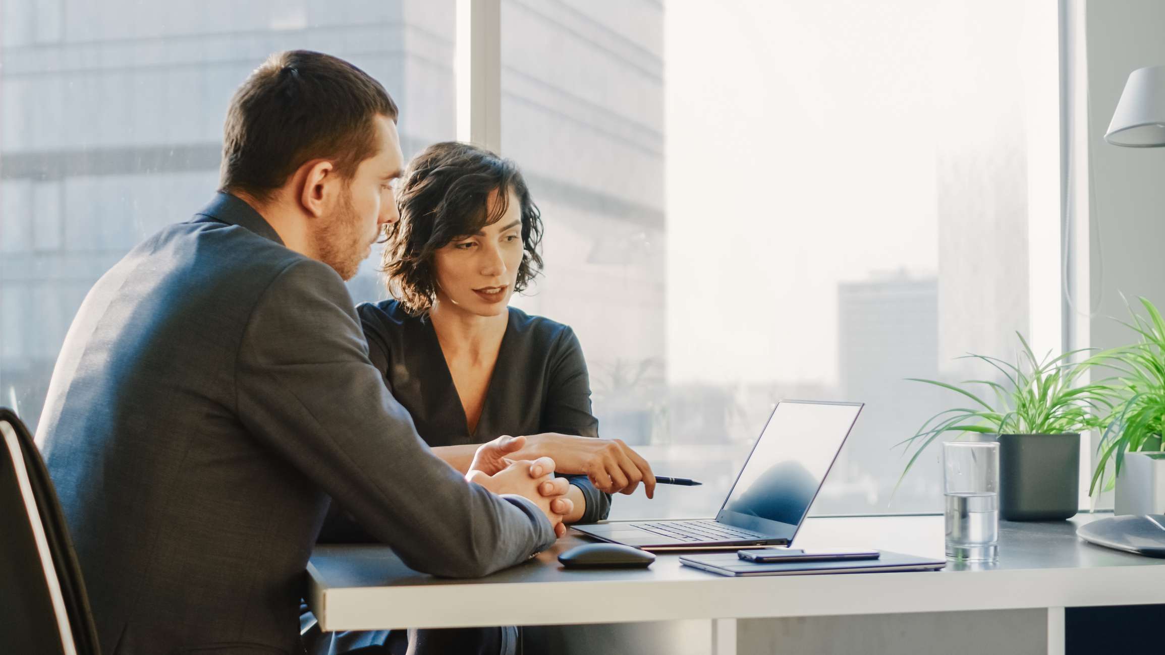 Two colleagues review information on a computer.