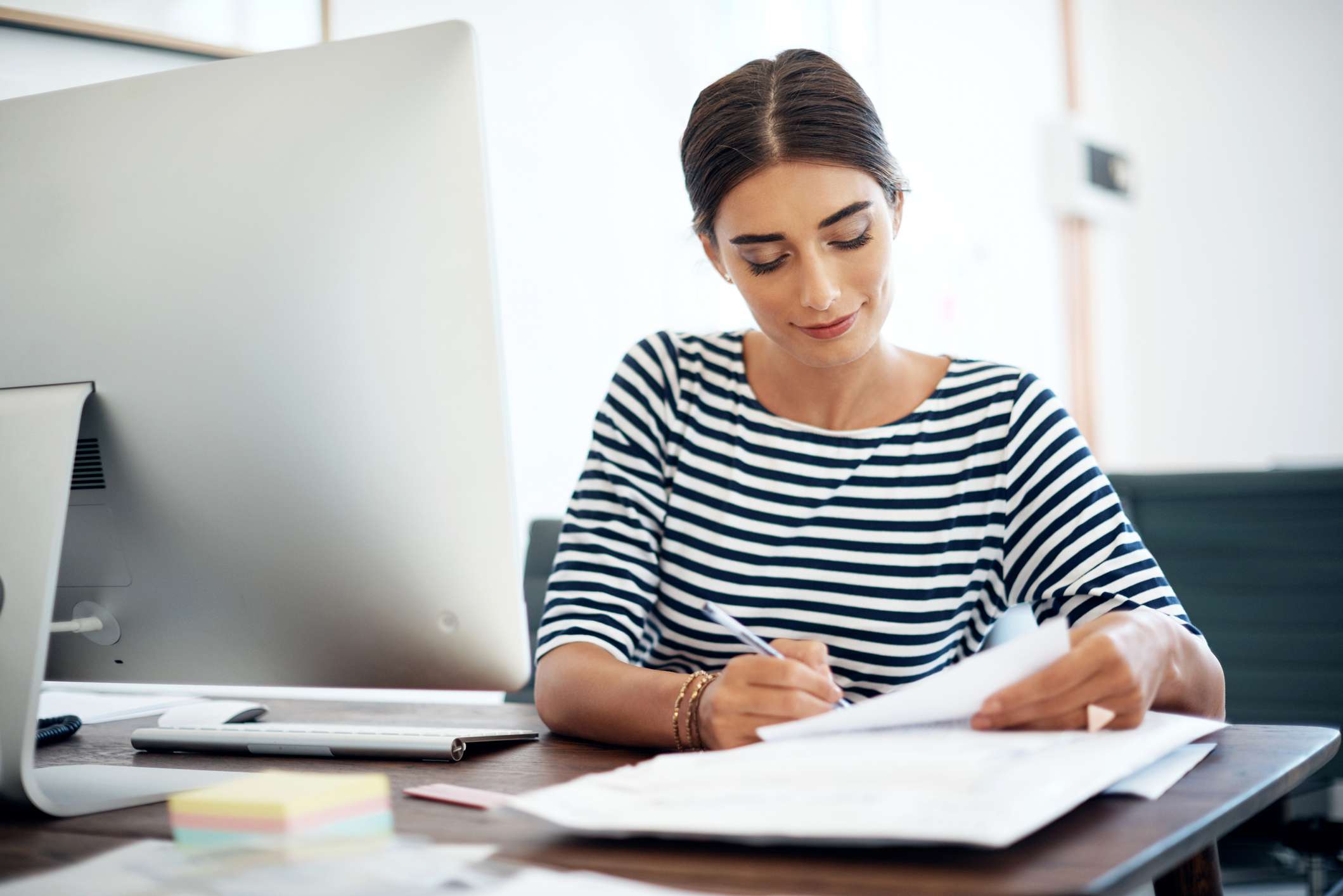 A woman fills out a loan application at a bank.