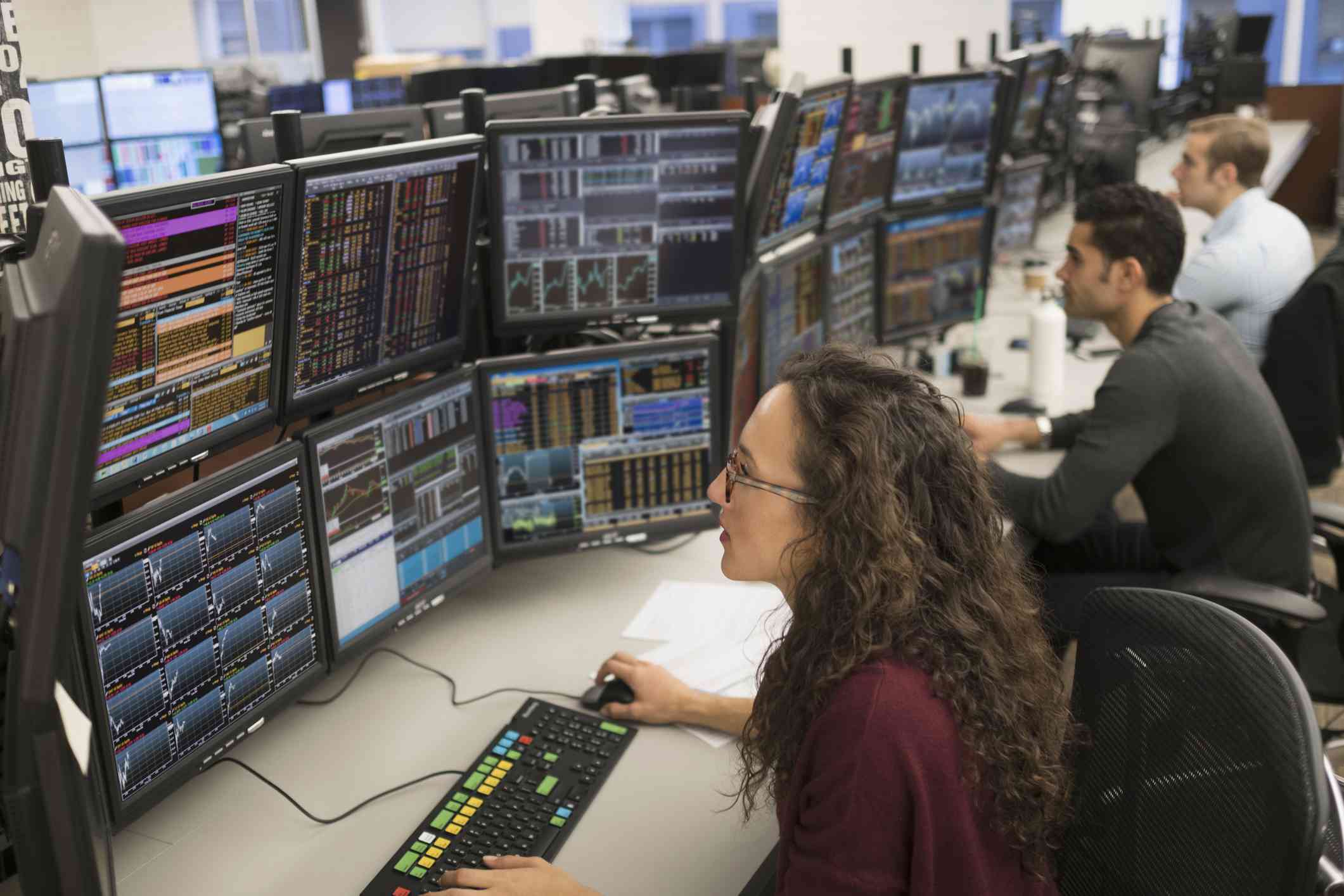 Young traders analyzing computer data.