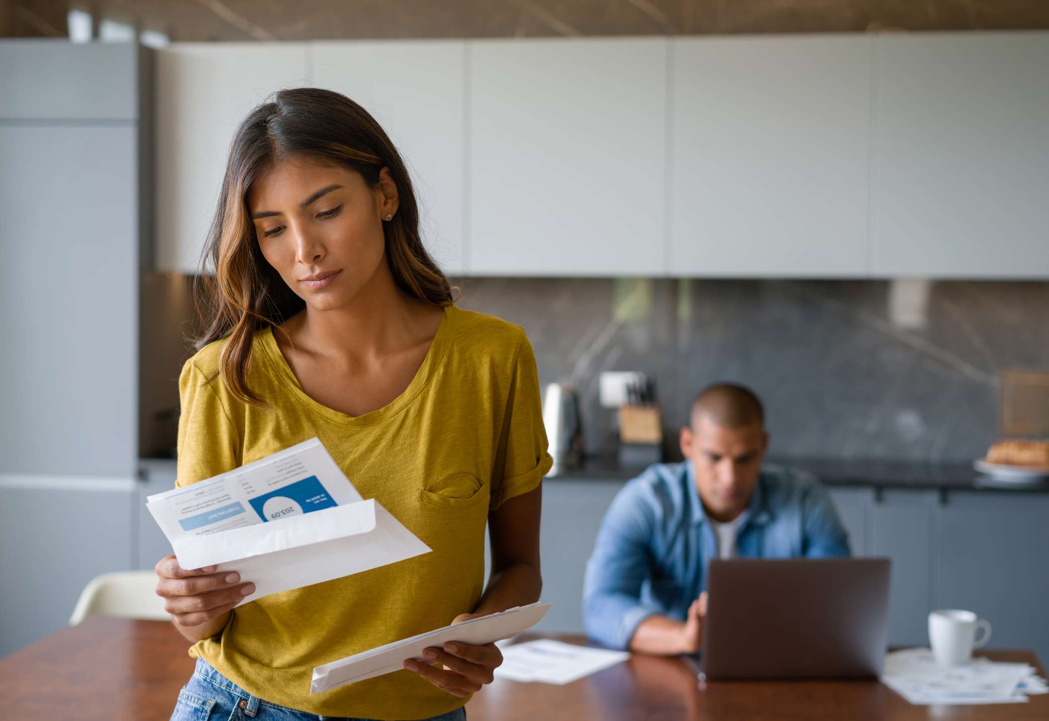 A woman looks concerned as she reads paperwork.